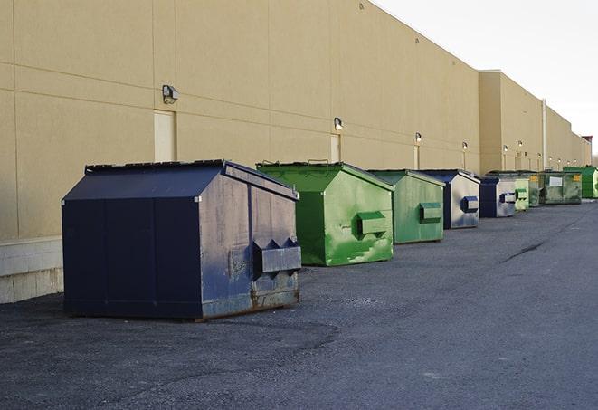 a row of construction dumpsters parked on a jobsite in Dover